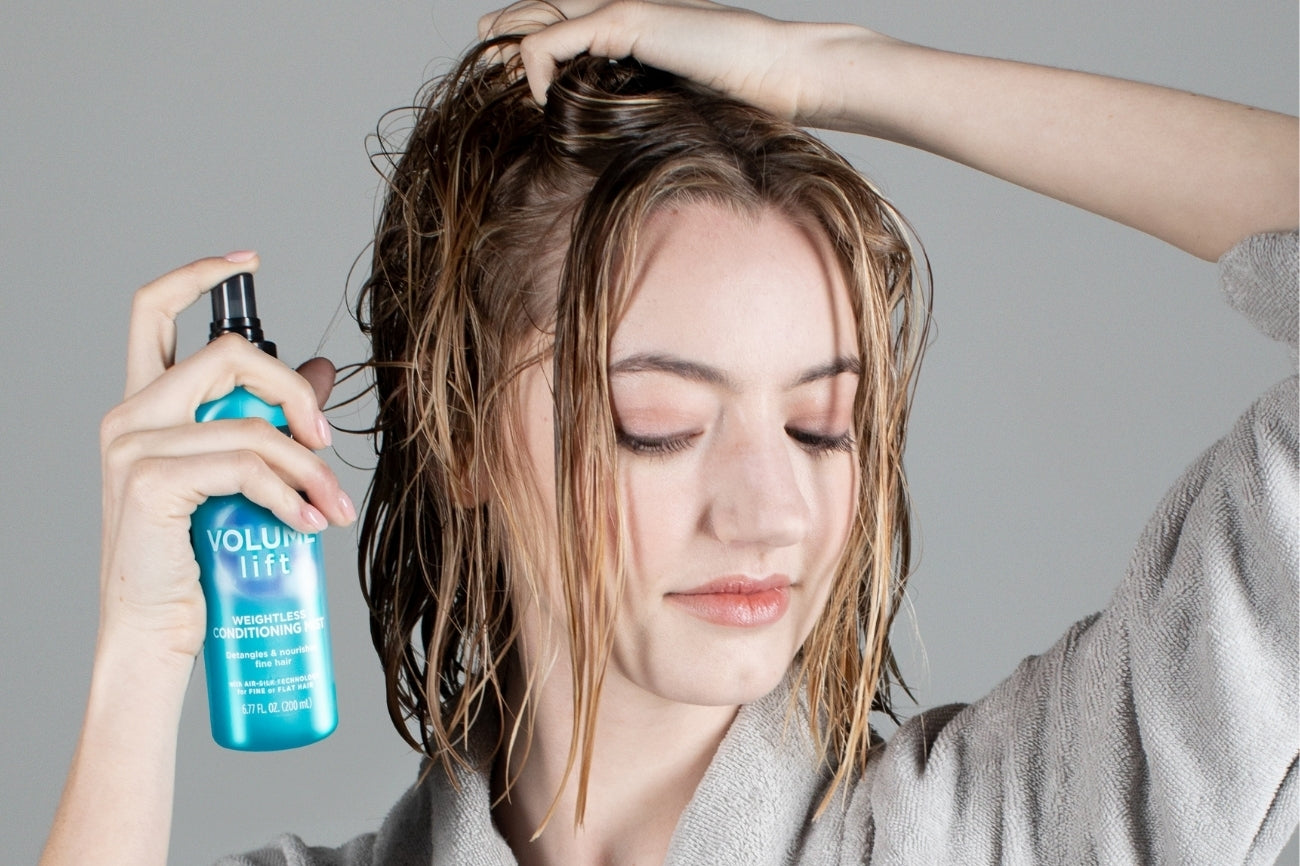 Woman spraying volume lift into her hair